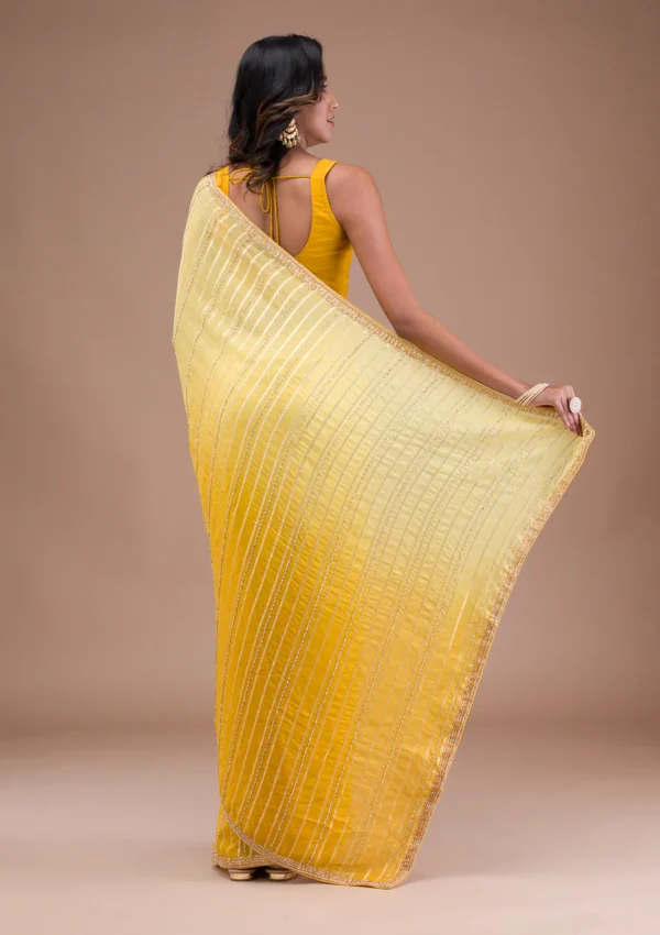 yellow organza saree with cutdana embroidery