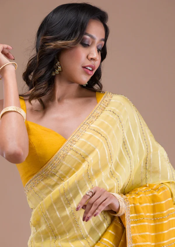 yellow organza saree with cutdana embroidery